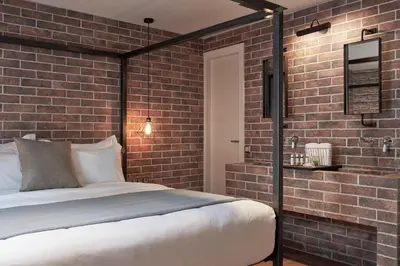 a bedroom with a brick wall and a bed at 18 Micon Str. in Athens