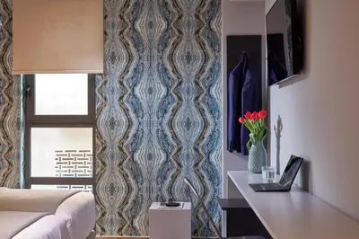 a bedroom with a blue and white wallpaper at 18 Micon Str. in Athens