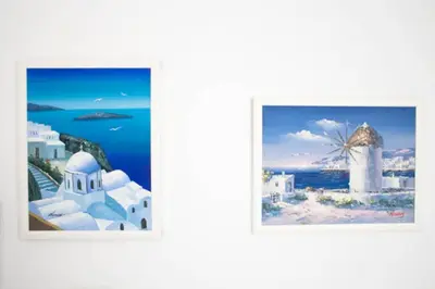 two pictures of the island of santorini with a windmill at Thelma's Apartment in Athens