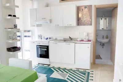 a white kitchen with a sink and a stove at Thelma's Apartment in Athens