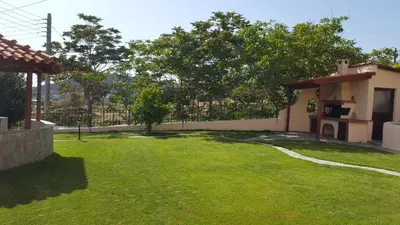 a backyard of a house with a green yard at Villa Christina in Anavissos