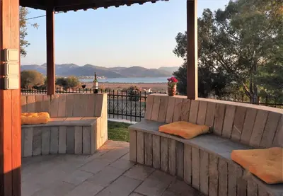 a patio with benches and a view of the water at Villa Christina in Anavissos