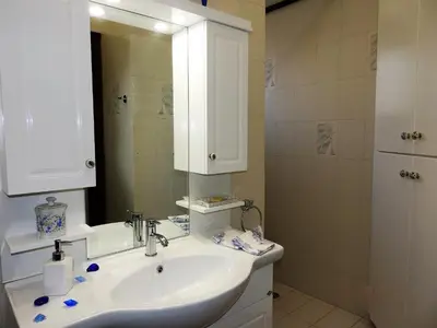 a bathroom with a sink and a mirror and a shower at Villa Christina in Anavissos