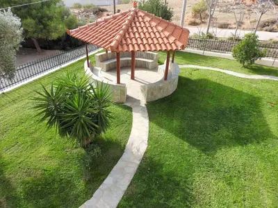 a gazebo with an umbrella on a grass field at Villa Christina in Anavissos