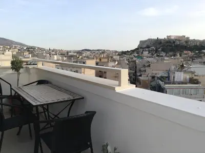 a balcony with a table and chairs and a city at Acropolis at Home: Loft with a View in Athens