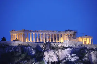 a building on top of a mountain at night at Acropolis at Home: Loft with a View in Athens