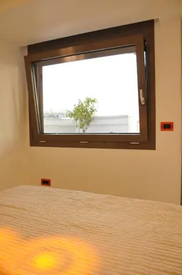 a bedroom with a window with a plant in it at Acropolis at Home: Loft with a View in Athens