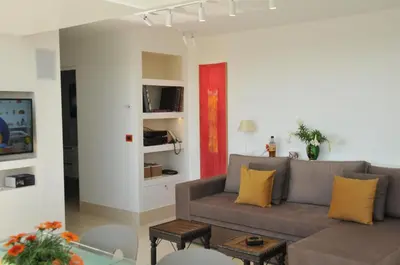 a living room with a gray couch and yellow pillows at Acropolis at Home: Loft with a View in Athens