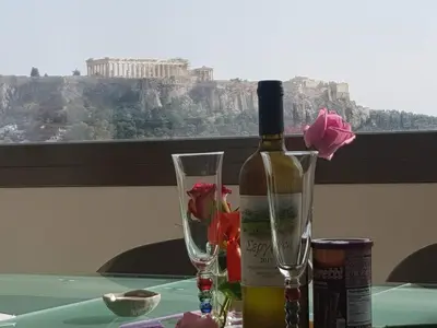 a bottle of wine and two glasses on a table at Acropolis at Home: Loft with a View in Athens