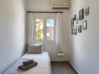 a small bedroom with a bed and a window at KYMA Apartments - Athens Acropolis 6 in Athens