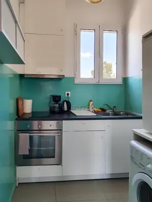 a kitchen with white appliances and green walls at KYMA Apartments - Athens Acropolis 6 in Athens