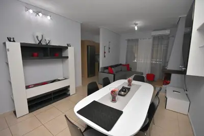 a living room with a white table and chairs at A&J Apartments or Rooms athens airport in Markopoulo