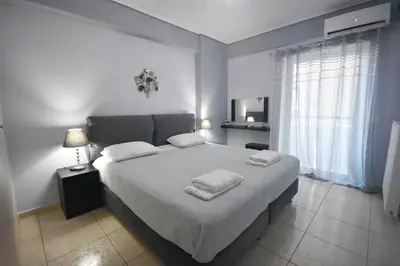 a bedroom with a large bed with two towels on it at A&J Apartments or Rooms athens airport in Markopoulo
