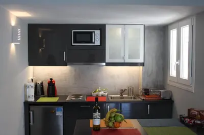 a kitchen with black cabinets and a table with fruit on it at Apartment in the Centre of Athens in Athens