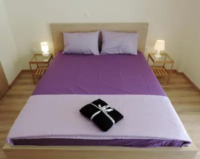 a purple bed with a black bow on it at Apartment in the Centre of Athens in Athens