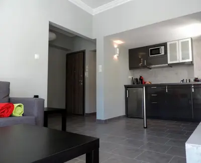 a living room with a couch and a kitchen at Apartment in the Centre of Athens in Athens