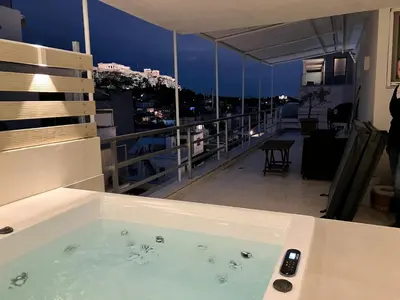 a bath tub sitting on top of a balcony at Syntagma Spa with Acropolis View in Athens