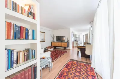 a living room with bookshelves and a dining room at Syntagma Spa with Acropolis View in Athens