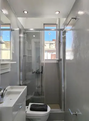 a bathroom with a shower and a toilet and a sink at KYMA Apartments - Athens Acropolis 3 in Athens