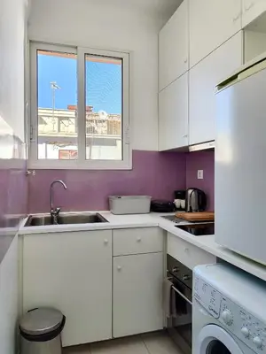 a kitchen with white cabinets and a sink and a window at KYMA Apartments - Athens Acropolis 3 in Athens