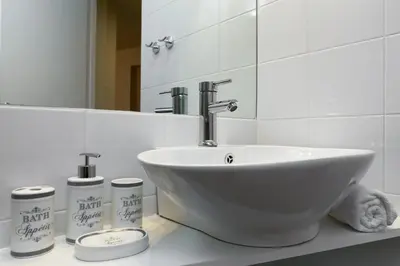 a bathroom with a white sink and a mirror at Vintage Apartment in the Heart of Plaka in Athens