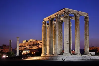 an ancient temple with columns in a city at night at Vintage Apartment in the Heart of Plaka in Athens