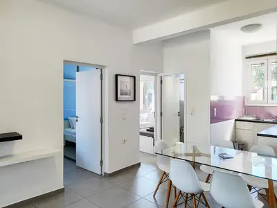 a dining room with a glass table and white chairs at KYMA Apartments - Athens Acropolis 4 in Athens