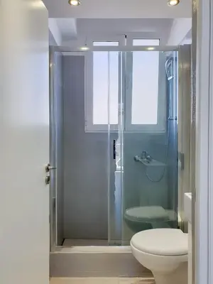 a bathroom with a glass shower with a toilet at KYMA Apartments - Athens Acropolis 4 in Athens