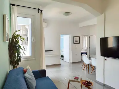 a living room with a blue couch and a tv at KYMA Apartments - Athens Acropolis 4 in Athens