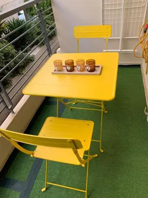 a yellow table and two chairs on a balcony at Glyfada Centre Studio in Athens