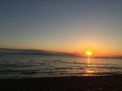 a sunset on the beach with the sun setting at Glyfada Centre Studio in Athens