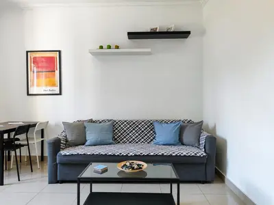 a living room with a blue couch and a table at KYMA Apartments - Athens Acropolis 1 in Athens
