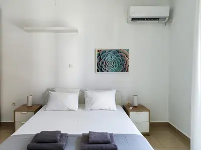 a bedroom with a white bed with two pillows at KYMA Apartments - Athens Acropolis 1 in Athens