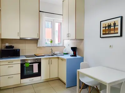 a kitchen with white cabinets and a blue refrigerator at KYMA Apartments - Athens Acropolis 1 in Athens