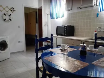 a kitchen with a blue table with chairs and a microwave at Cosy Apartment Pinotsi in Athens