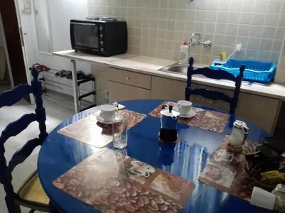 a kitchen with a blue table with chairs and a microwave at Cosy Apartment Pinotsi in Athens