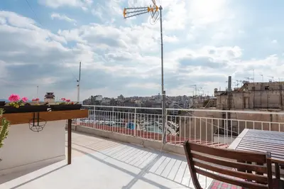 a balcony with a bench and a view of a city at Piraeus Apartment with Endless View in Piraeus