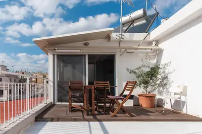 a patio with chairs and a table on a balcony at Piraeus Apartment with Endless View in Piraeus