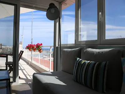 a living room with a couch in front of a window at Piraeus Apartment with Endless View in Piraeus