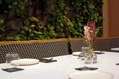 a table with plates and a vase with flowers on it at Hotel Lozenge in Athens