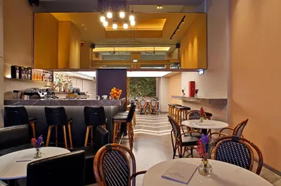 a restaurant with tables and chairs and a bar at Hotel Lozenge in Athens