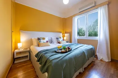a bedroom with a bed with a tray of food on it at Hidesign Athens Plaka Apartment in Acropolis in Athens
