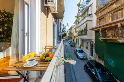 a table with a bowl of fruit on a balcony at Hidesign Athens Plaka Apartment in Acropolis in Athens
