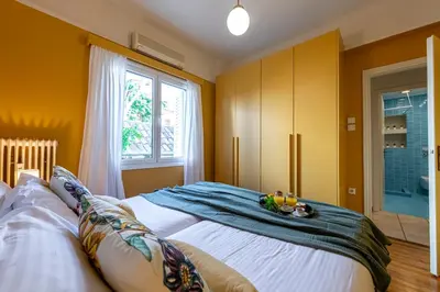 a bedroom with two beds and a window at Hidesign Athens Plaka Apartment in Acropolis in Athens