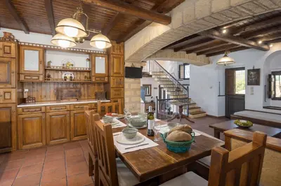 a large kitchen with a wooden table and chairs at Four Seasons Stonework Castle in Lagonissi