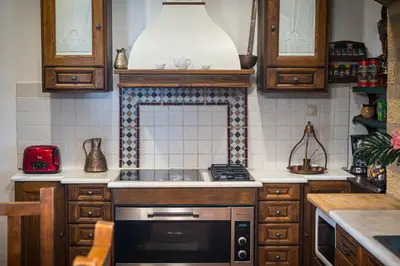 a kitchen with wooden cabinets and a stove top oven at Four Seasons Stonework Castle in Lagonissi