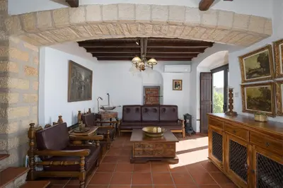 a living room with a couch and a table and chairs at Four Seasons Stonework Castle in Lagonissi