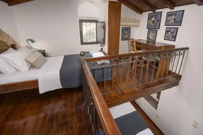 a small bedroom with a bed and a staircase at Four Seasons Stonework Castle in Lagonissi