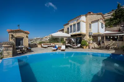 a large swimming pool in front of a house at Four Seasons Stonework Castle in Lagonissi