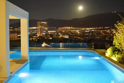 a swimming pool on the roof of a building at night at Athens Lycabettus Hill Penthouse, Private Roof Garden & Pool in Athens